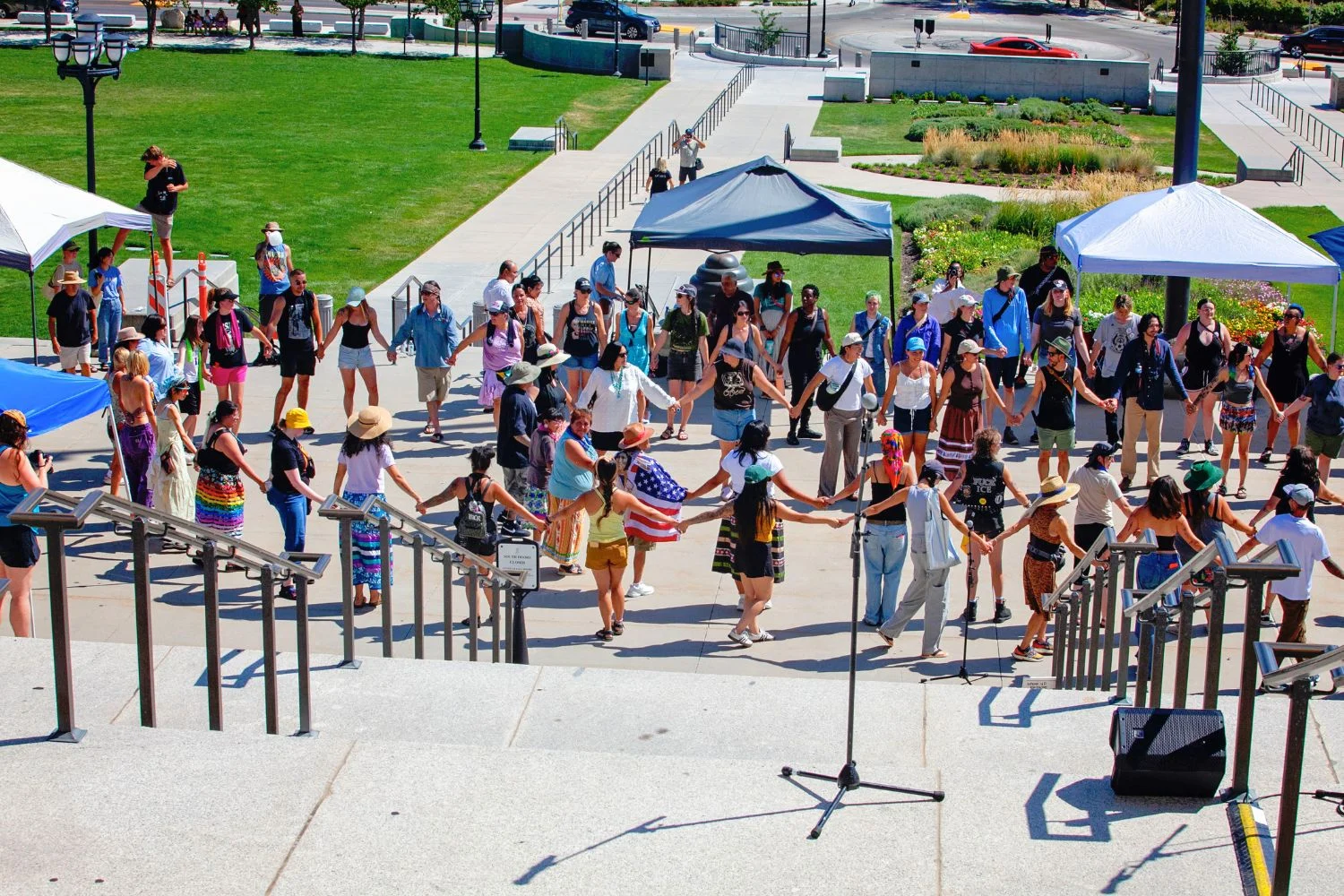 beyc-2026-monument-dance-rally Participants hold hands in a circle during a Monument dance rally.