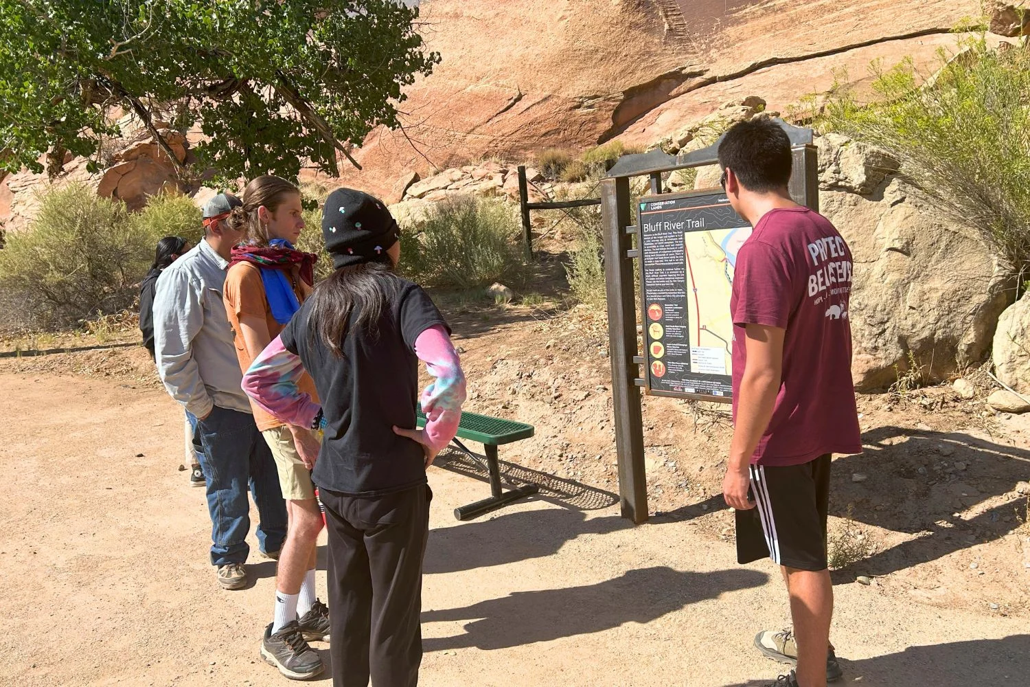 eyc-2026-bluff-river-trail-01 Bears Ears Youth Council participants gather around the Bluff River Trail information sign.